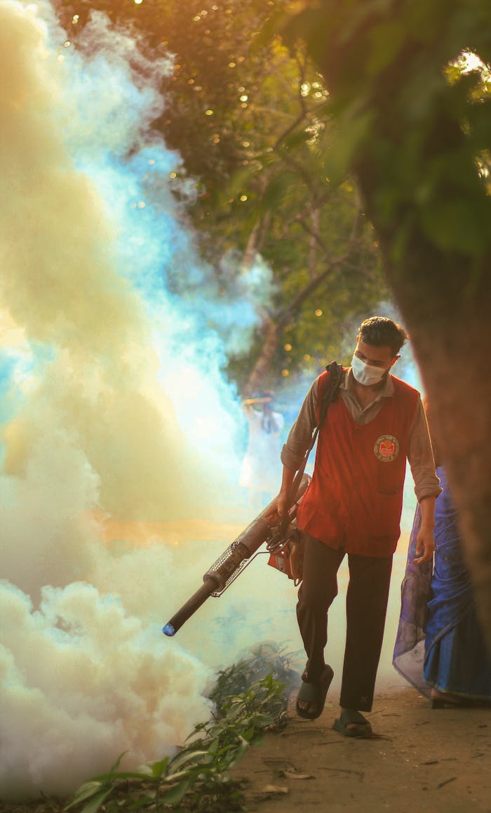 services-03 A worker performs fogging to control mosquitoes in a city park during the afternoon.