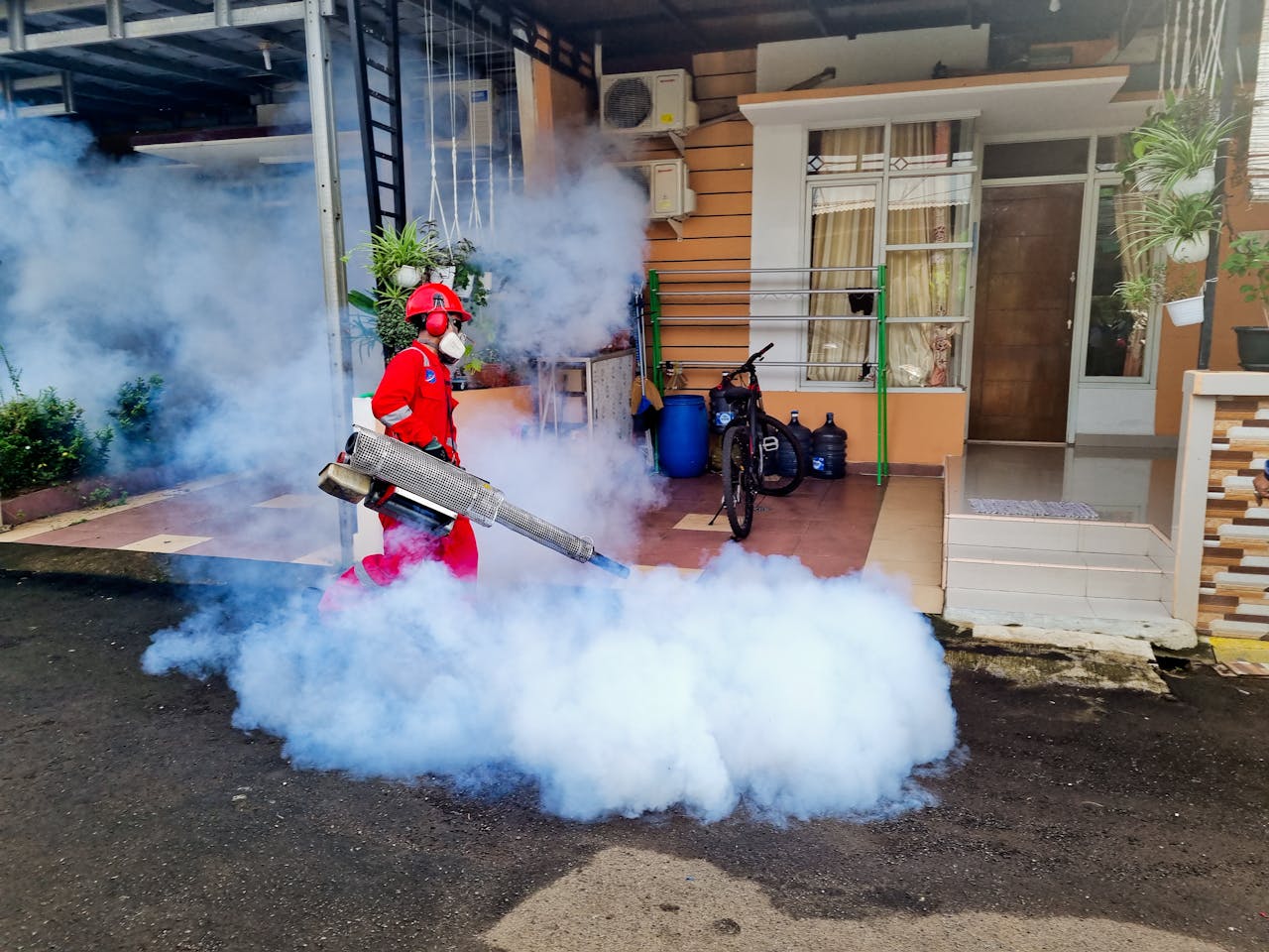 The Art of Drawing Readers In: Your attractive post title goes here Pest control specialist using a smoke machine to fumigate outside a house.